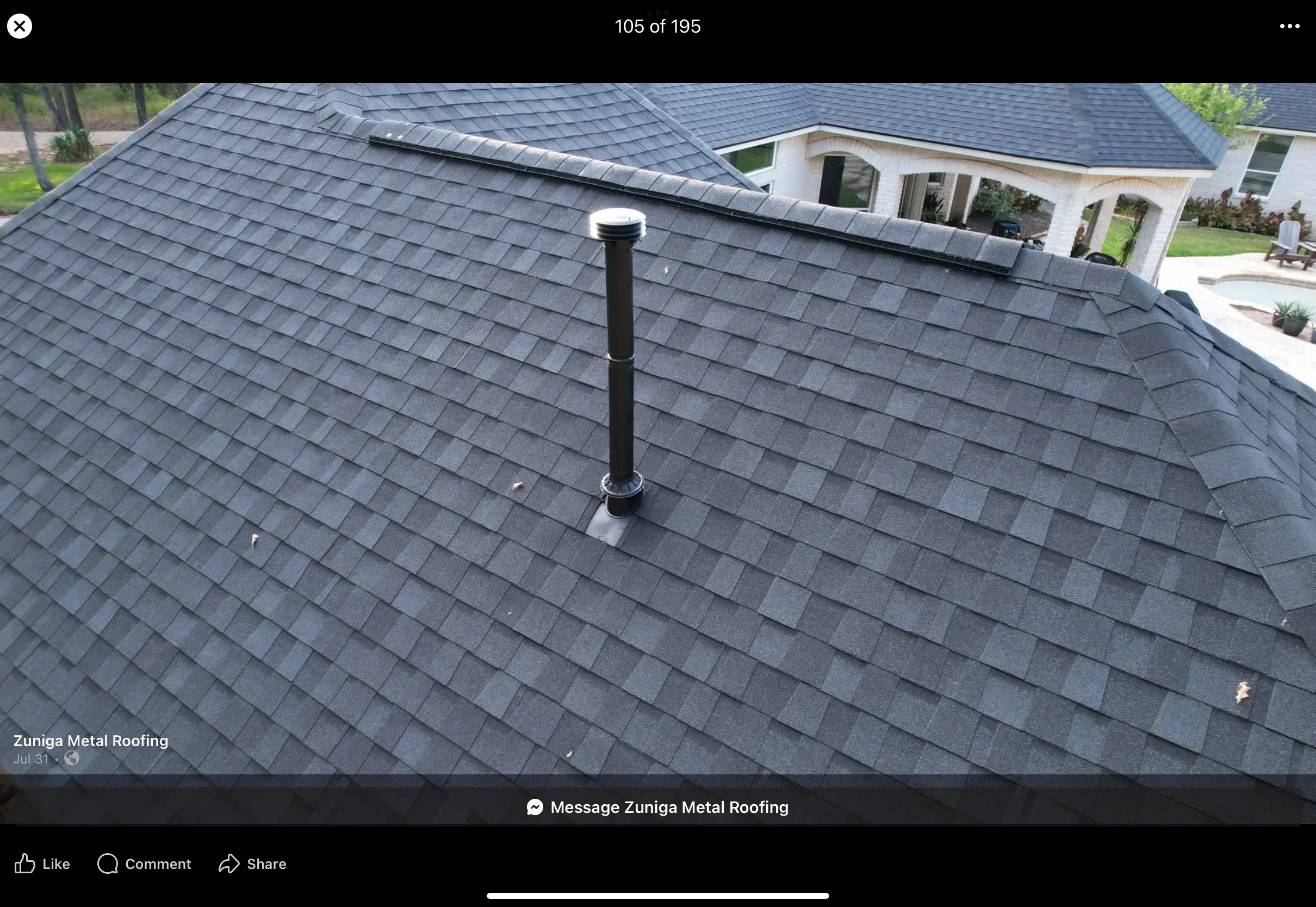 Charcoal gray metal roof with standing seam panels and chimney flashing on residential home