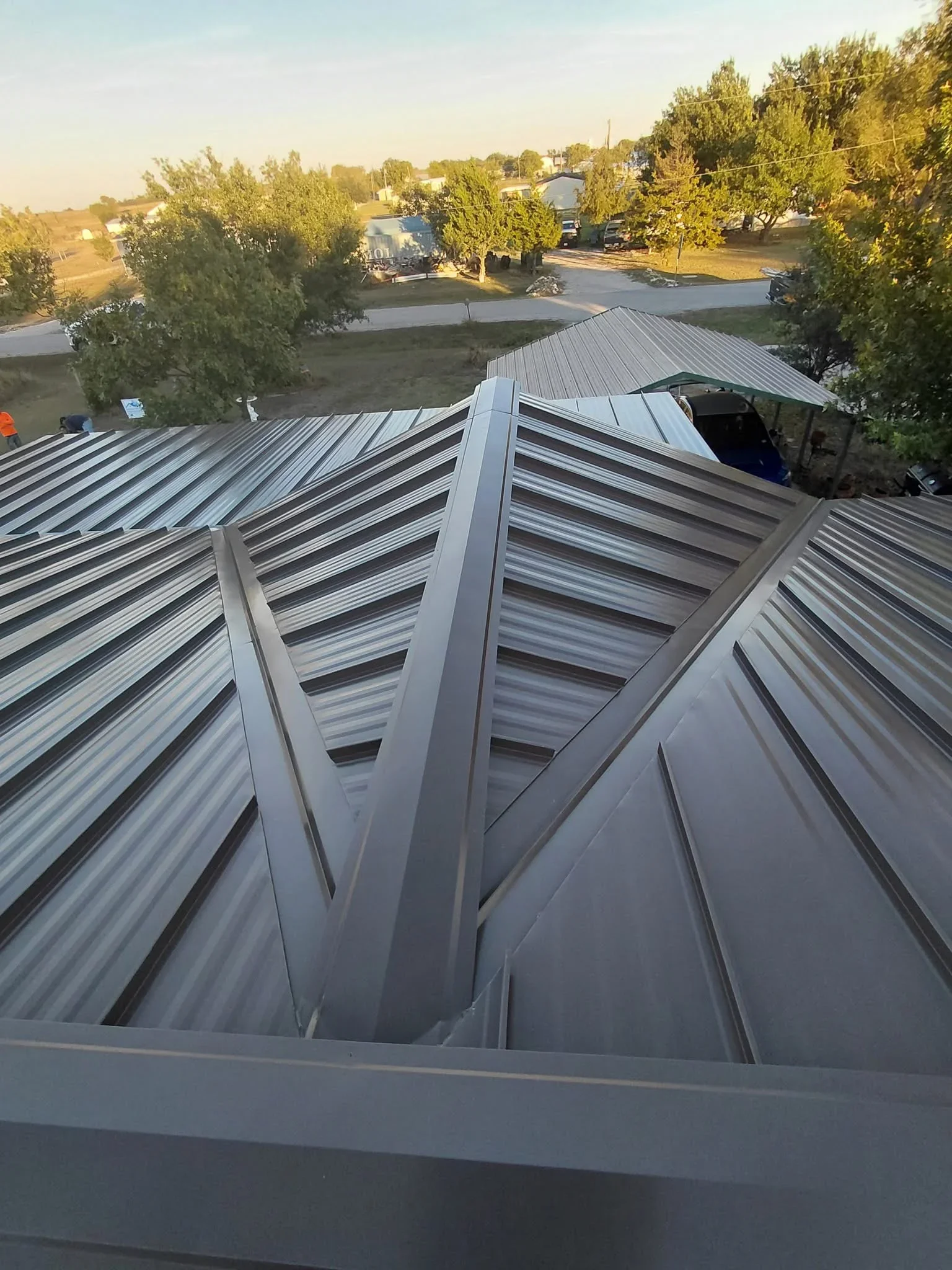 Standing seam metal roof with ridge vent and vertical panel installation