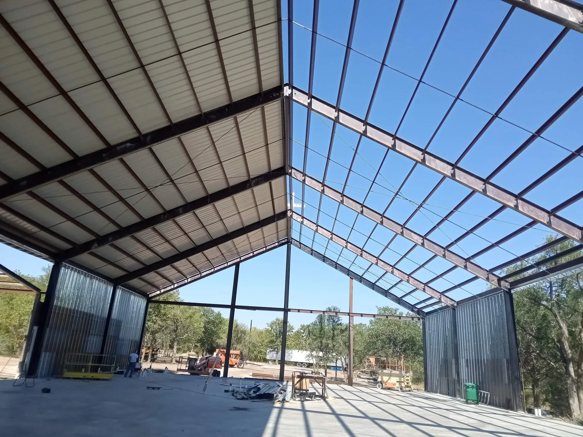 Steel frame carport with polycarbonate roof panels and corrugated metal siding