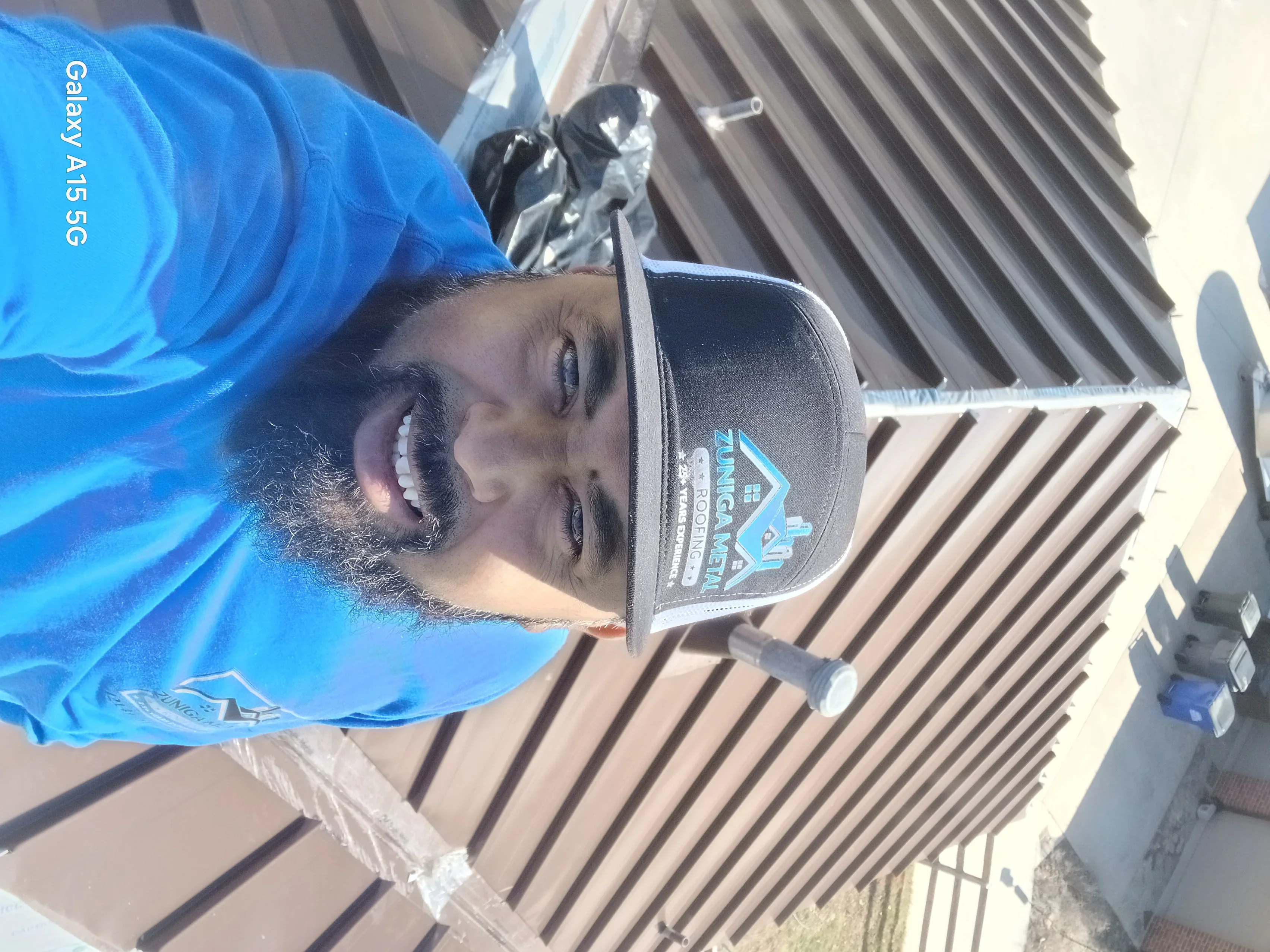 Standing seam metal roof installation with corrugated panels and white fasteners