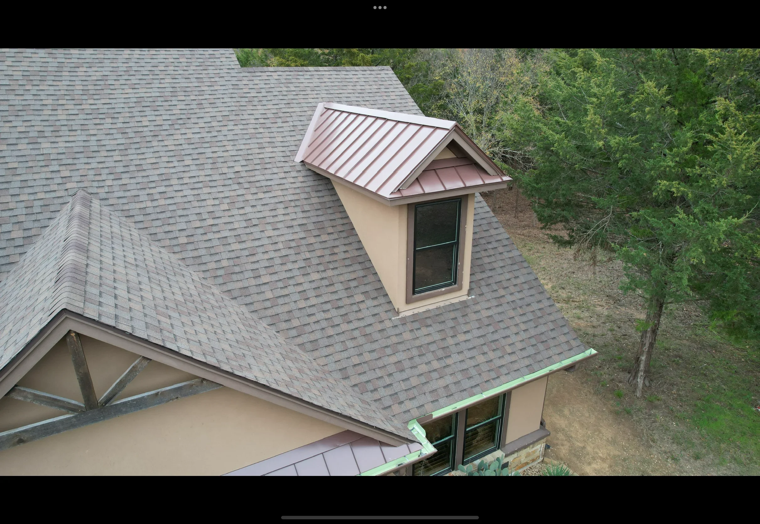 Standing seam metal roof with mauve panels and dormer, architectural shingles, integrated gutters