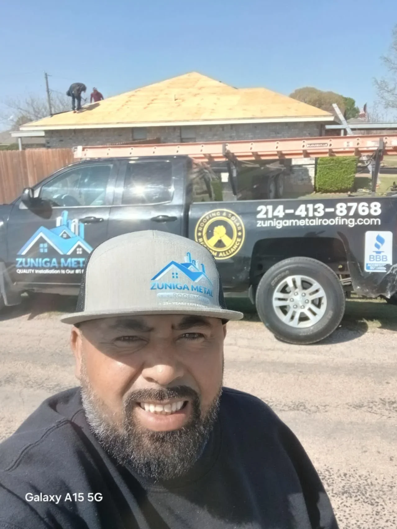Metal roof installation with standing seam panels on pitched residential roof structure