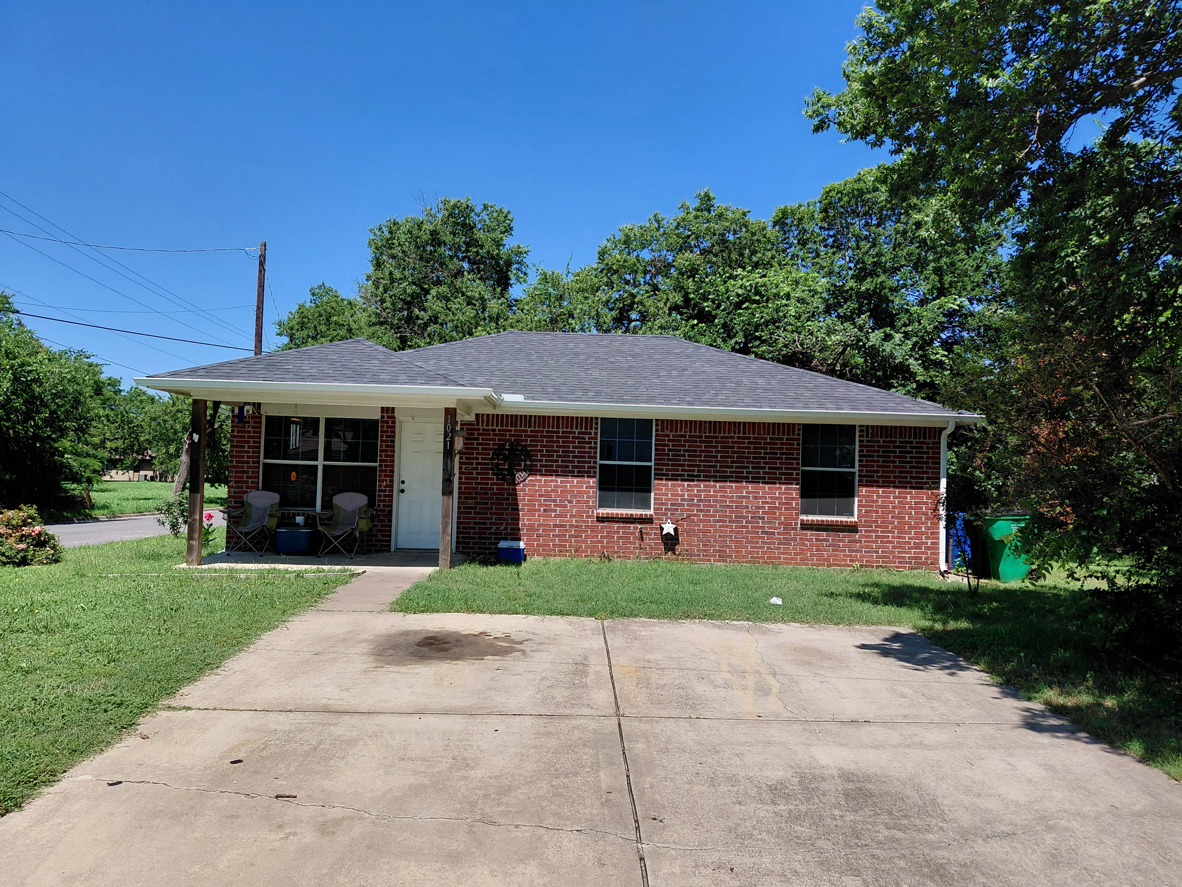 Gray asphalt shingle roof on brick residential home with wide overhang and proper flashing