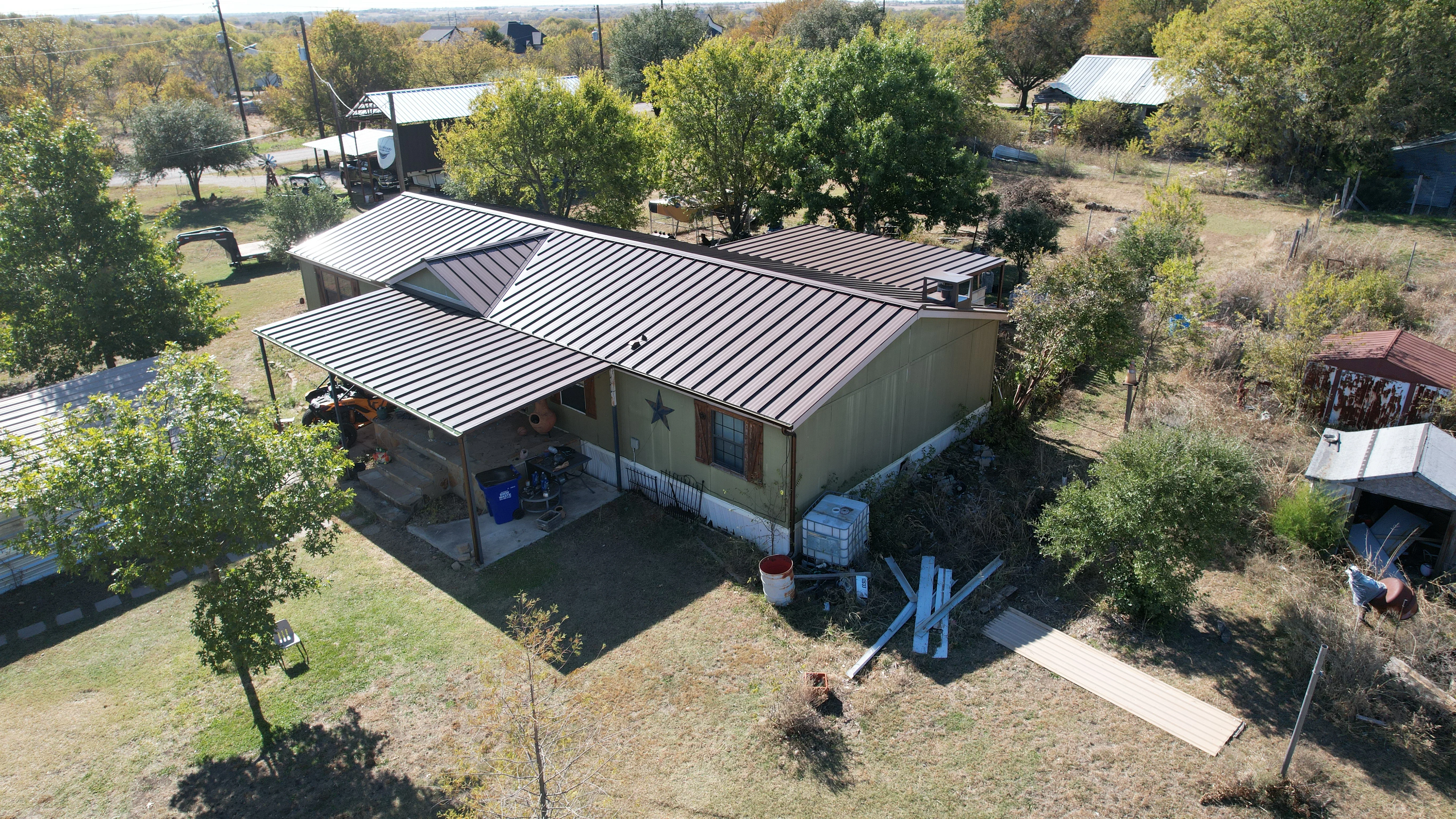 Standing seam metal roof installation on residential home with gray metal panels