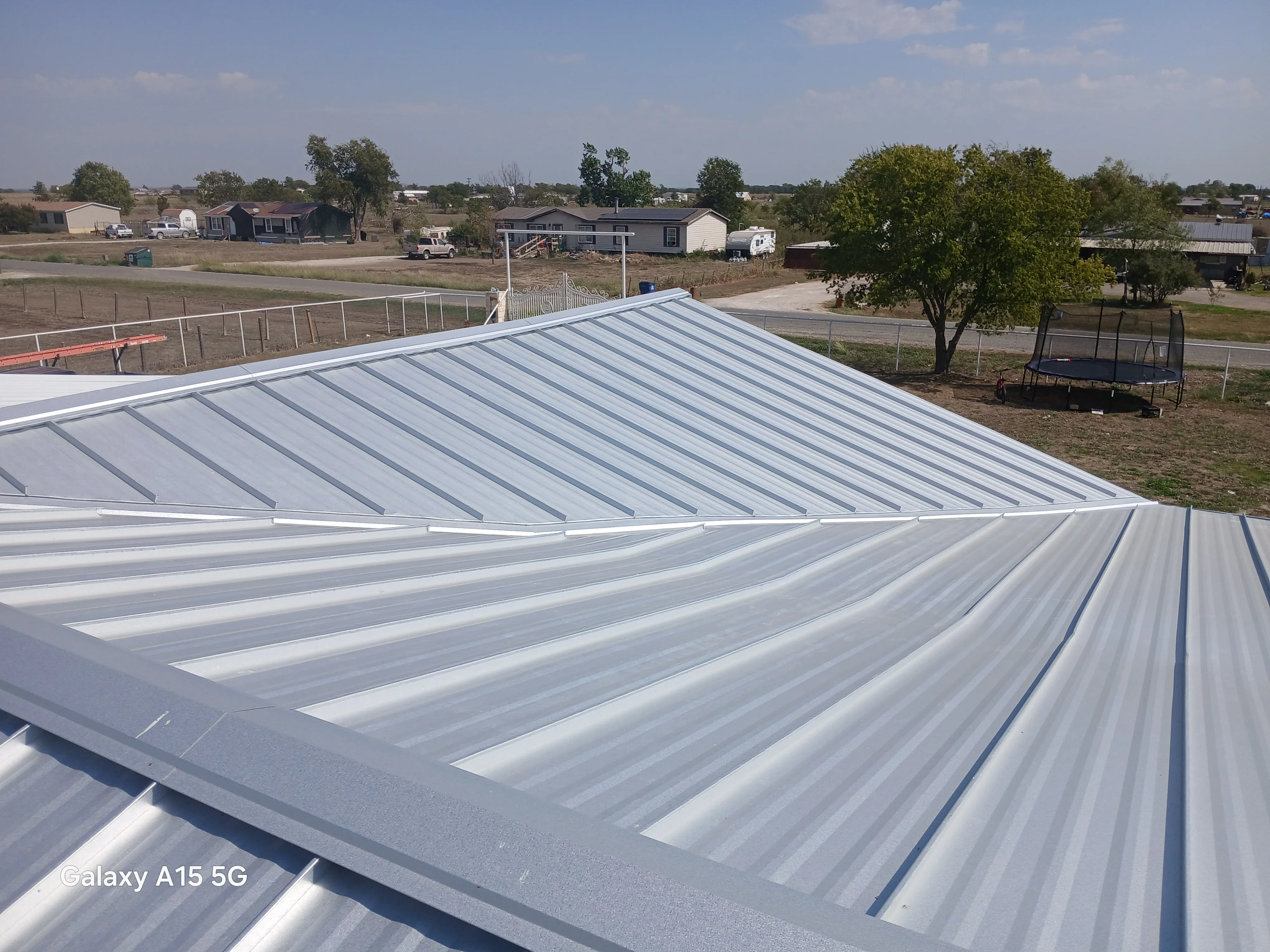 Standing seam metal roof with vertical ribs and professional seaming on residential structure