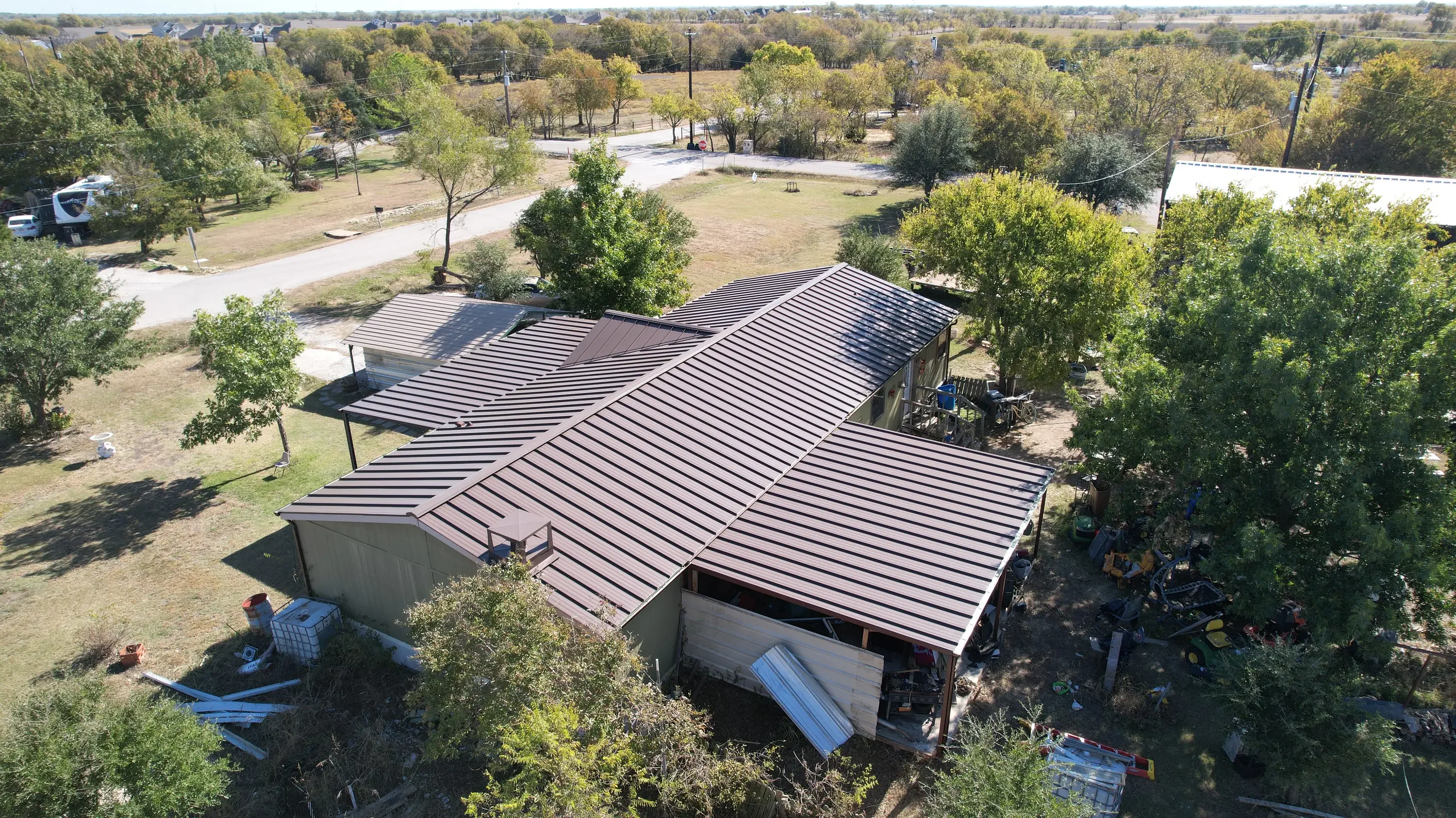 Standing seam metal roof installation with dark gray panels on residential structure