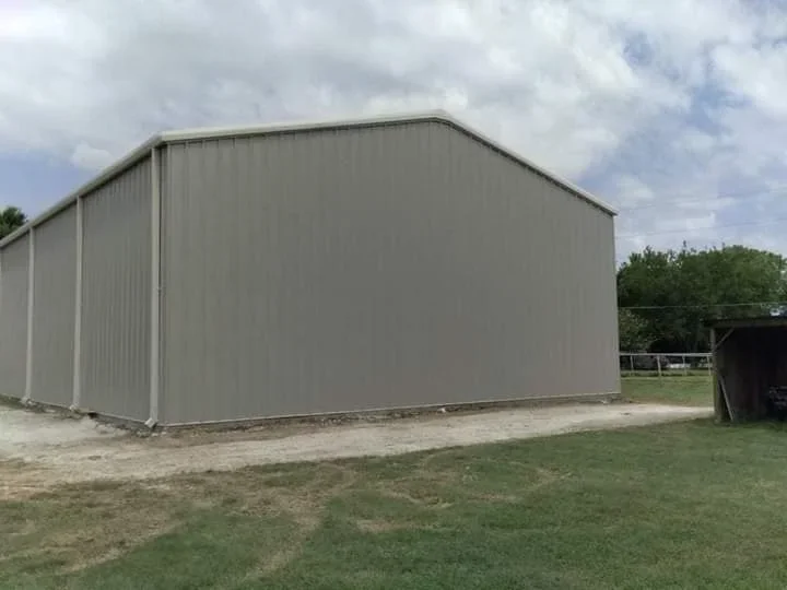 Corrugated metal building with pitched roof and steel panel siding