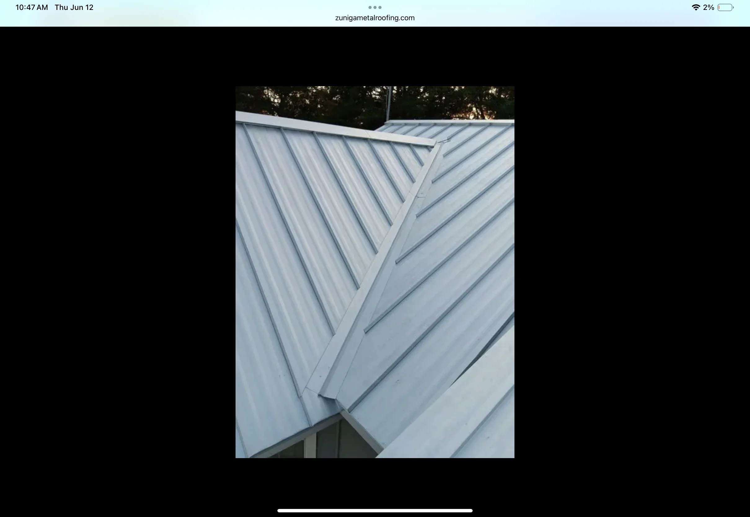 Standing seam metal roof with vertical ribs and ridge cap installation