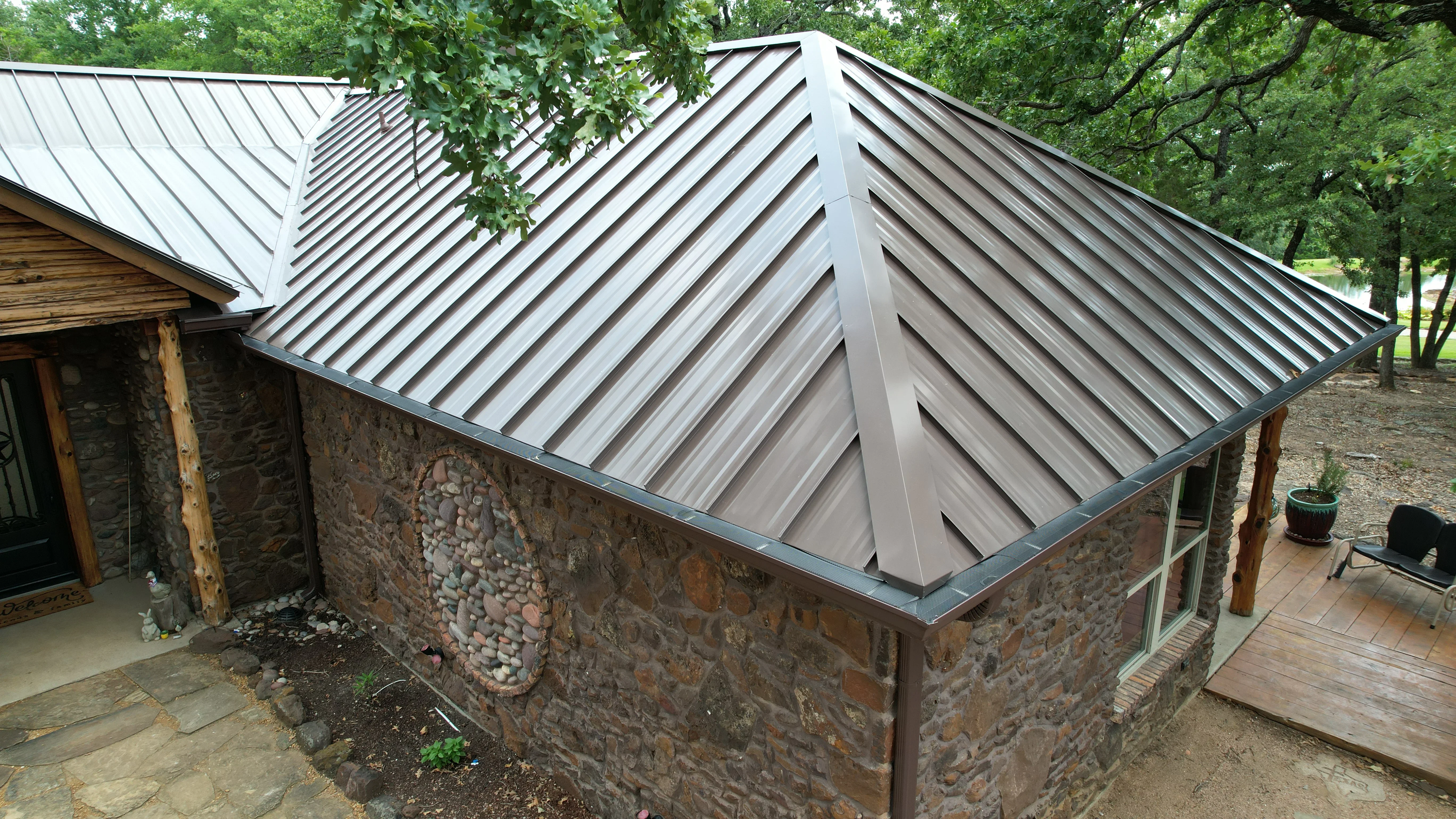 Standing seam metal roof with gray panels on stone masonry building with gabled design