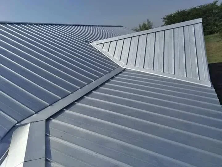 Standing seam metal roof with gray finish and integrated flashing at roof valleys