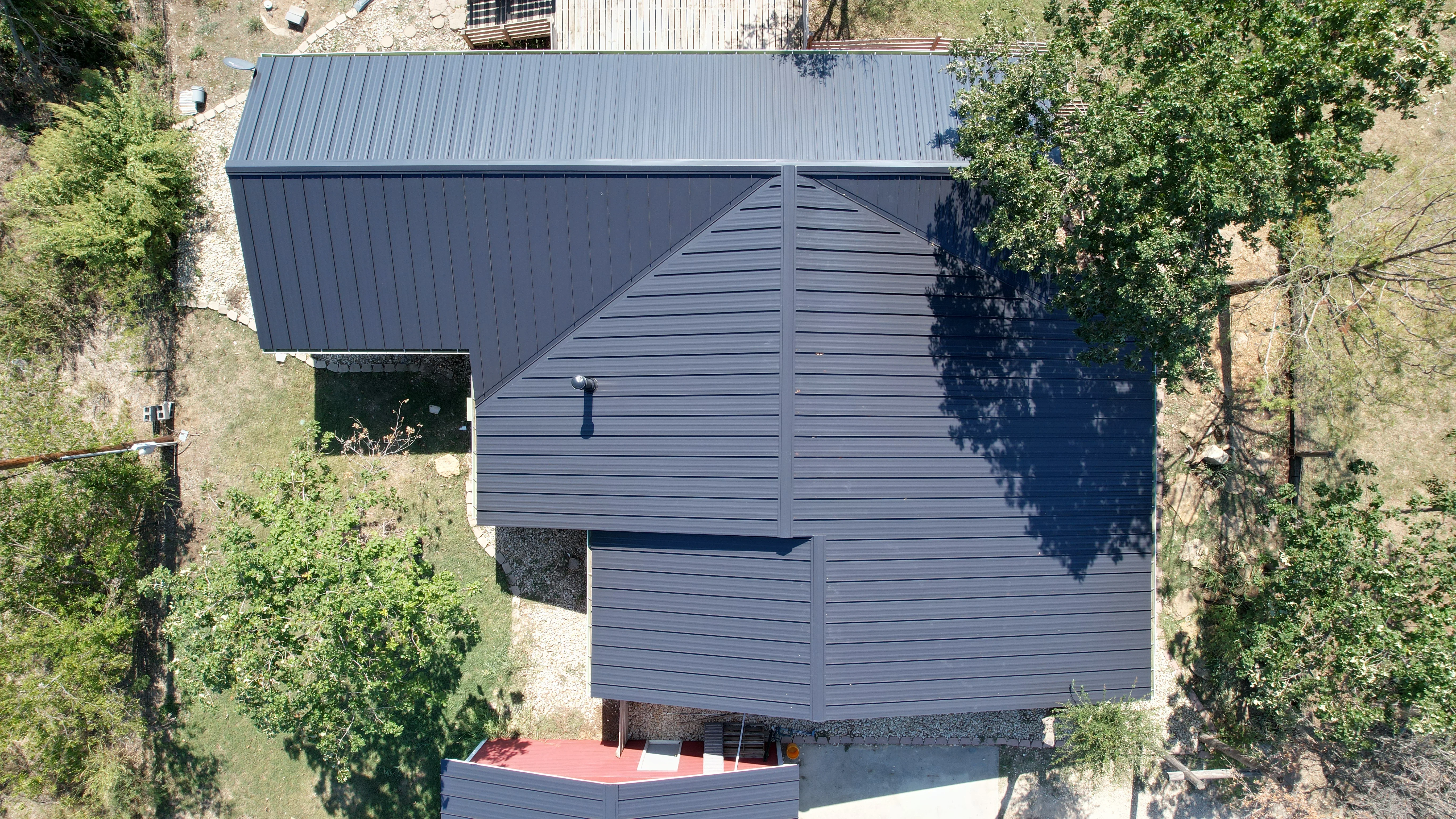 Aerial view of charcoal gray standing seam metal roof and siding on residential building