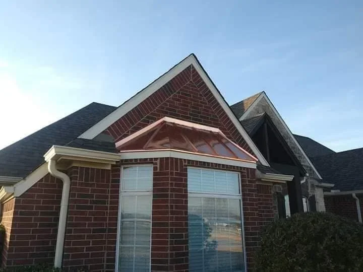 Two-story brick home with new charcoal gray asphalt shingle roof and white gutters