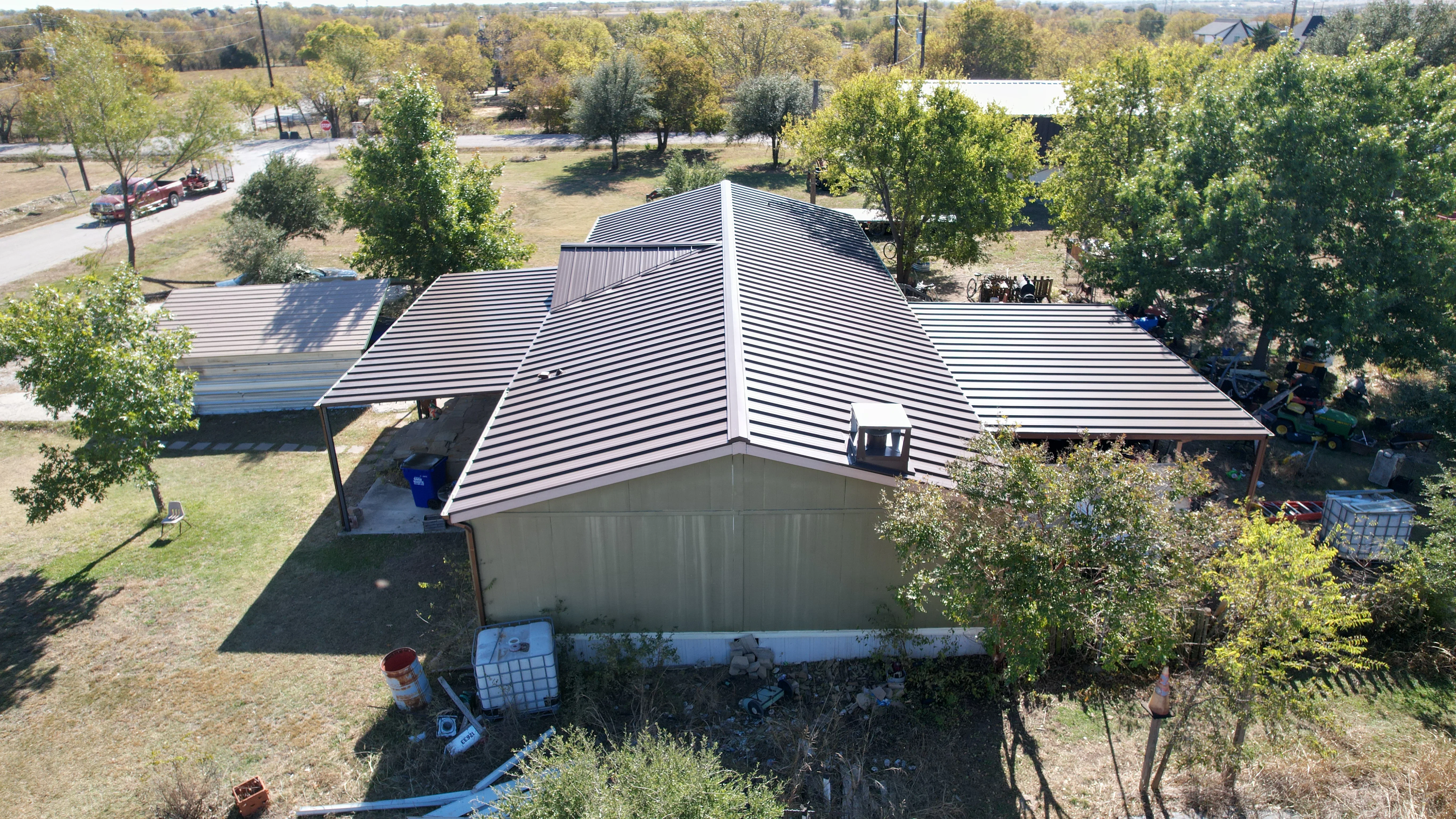 Standing seam metal roof with white trim and multiple peaks on residential structure