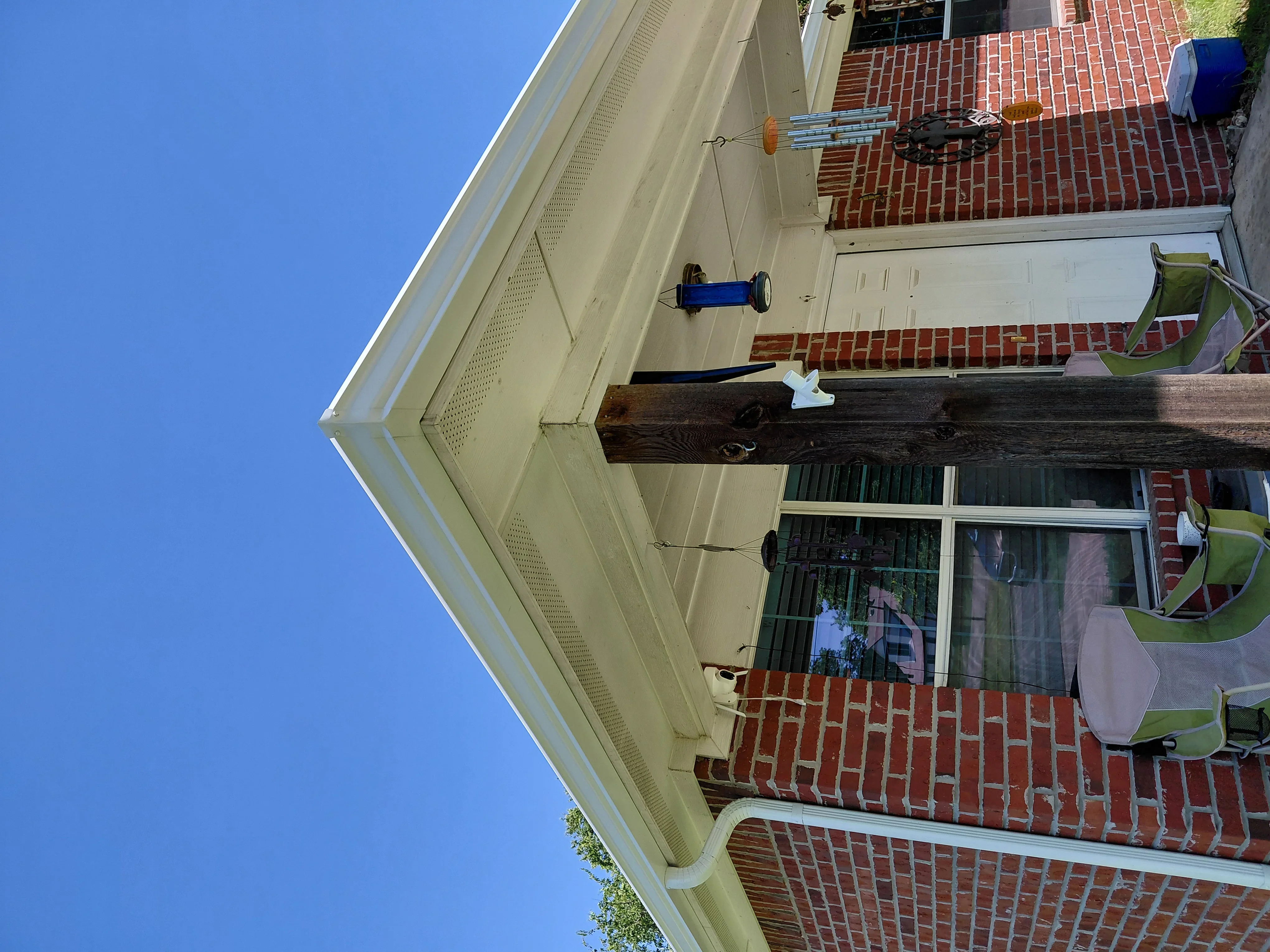 Red clay tile roof on brick home with cream fascia and white guttering system