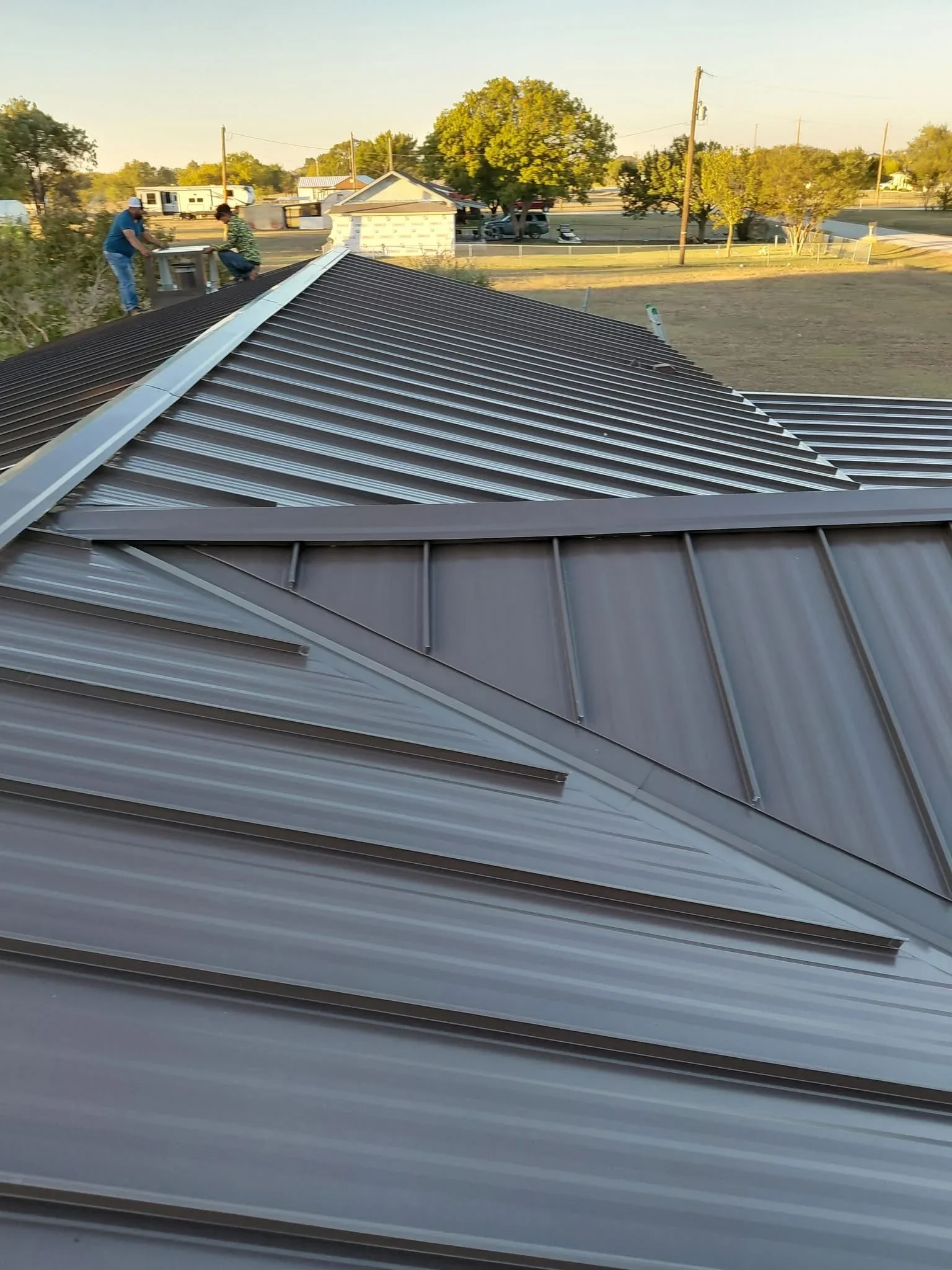 Standing seam metal roof with charcoal gray panels and clean seam lines installed on residential structure