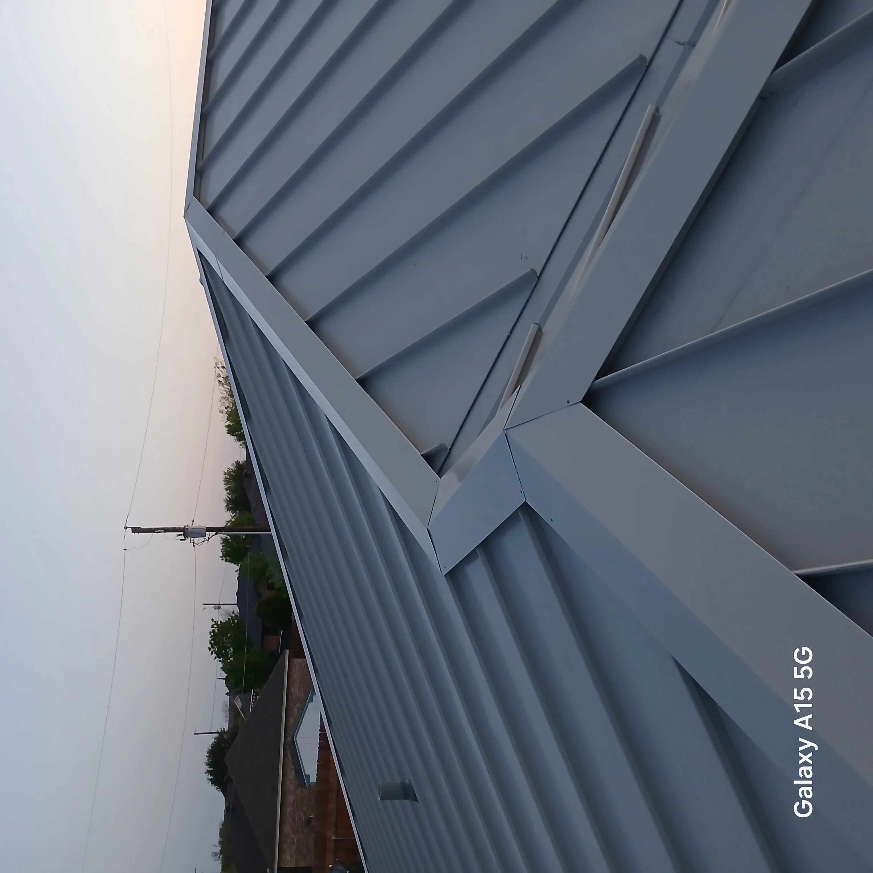 Gray standing seam metal roof with professional seaming and flashing installation