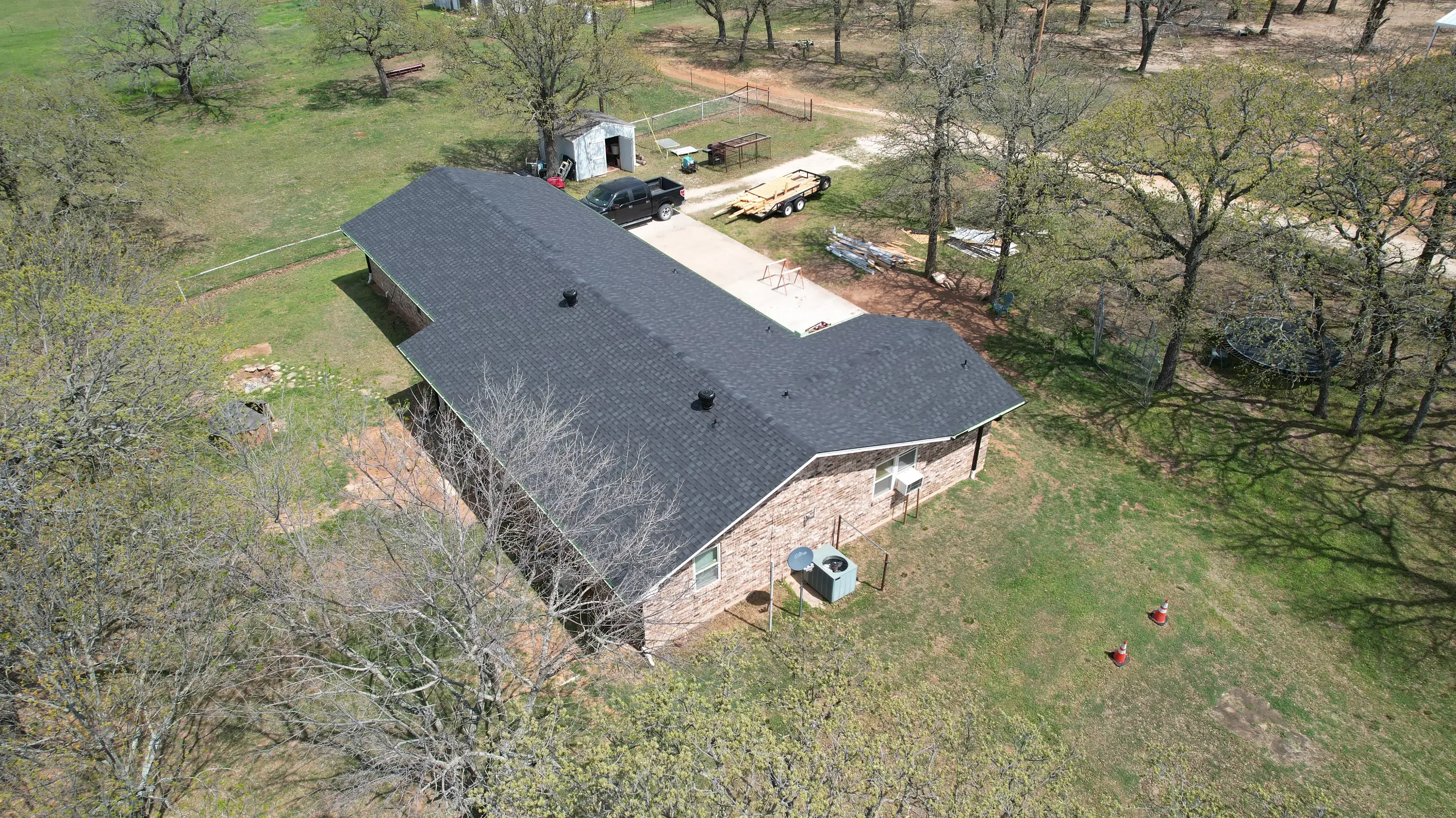 Dark gray metal shingle roof installed on brick residential building with proper ventilation
