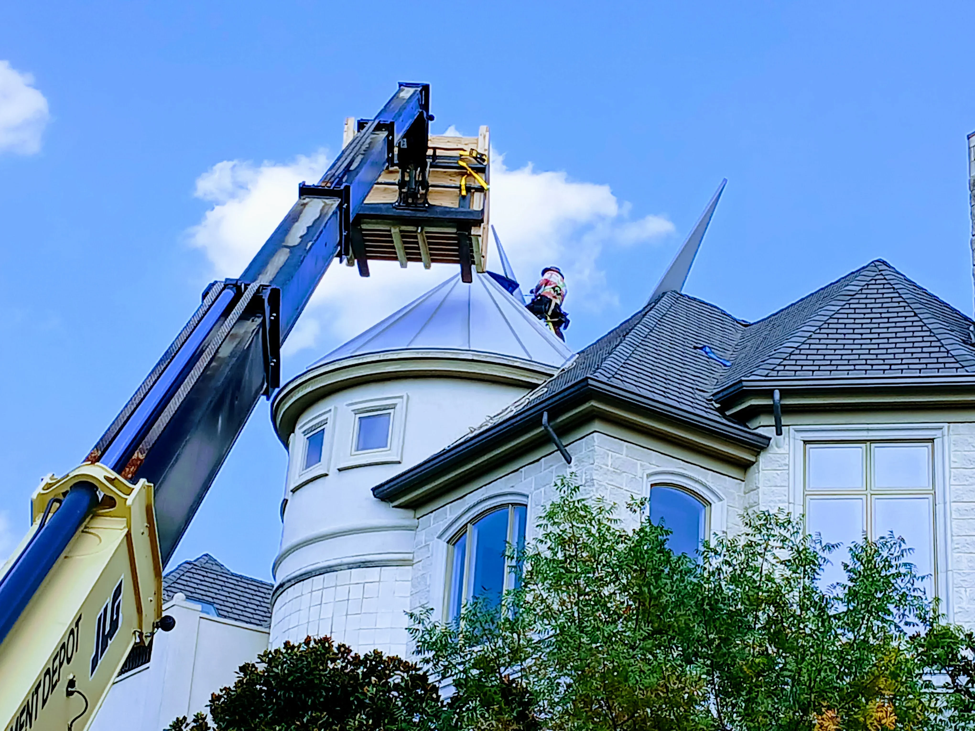Metal roofing installation on curved dome structure with standing seam panels and architectural tower