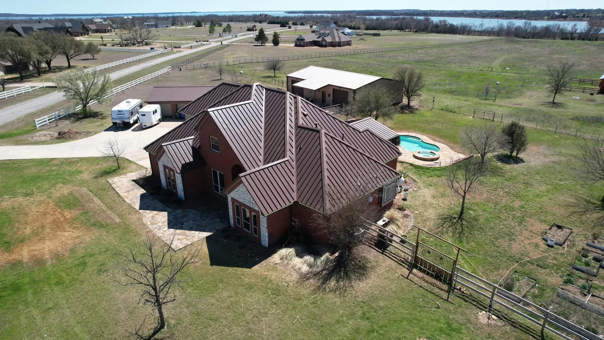 Standing seam metal roof on brick home with multiple pitched sections and dark finish