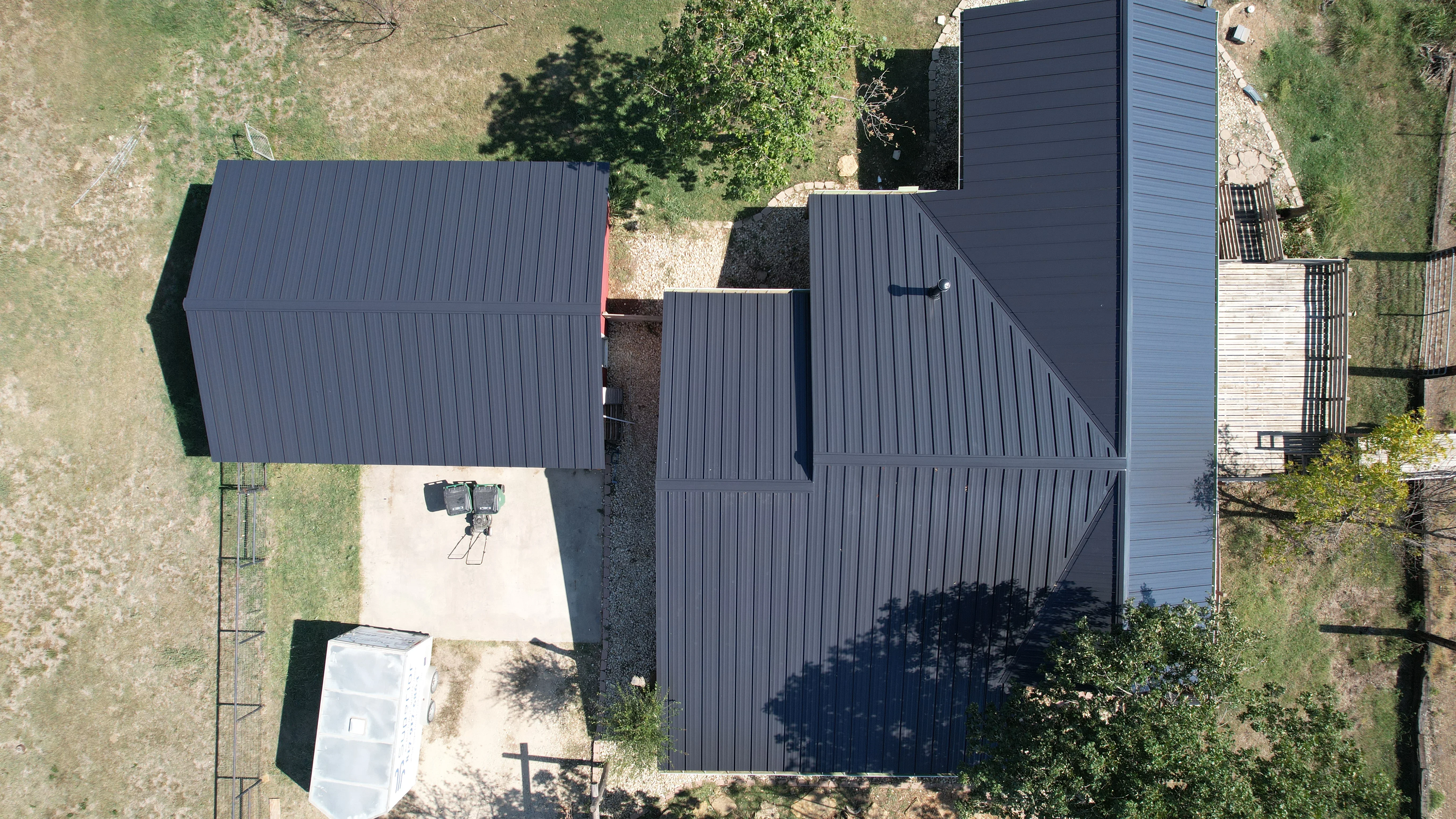 Aerial view of dark gray standing seam metal roof installation on residential structure