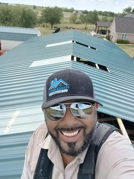 Light blue standing seam metal roof with two skylight openings installed on residential structure