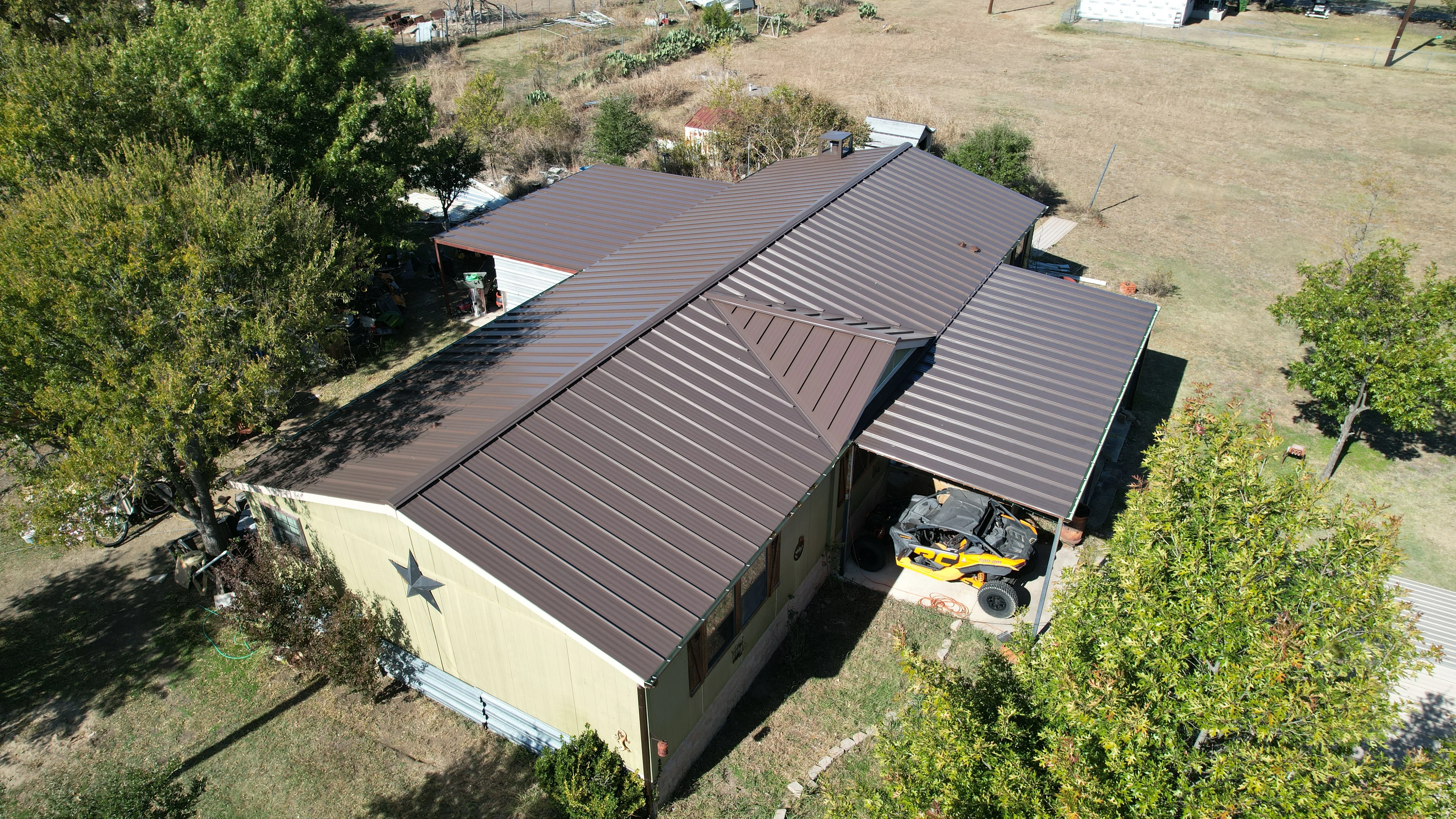 Dark brown standing seam metal roof on storage building with multiple pitched sections and valleys