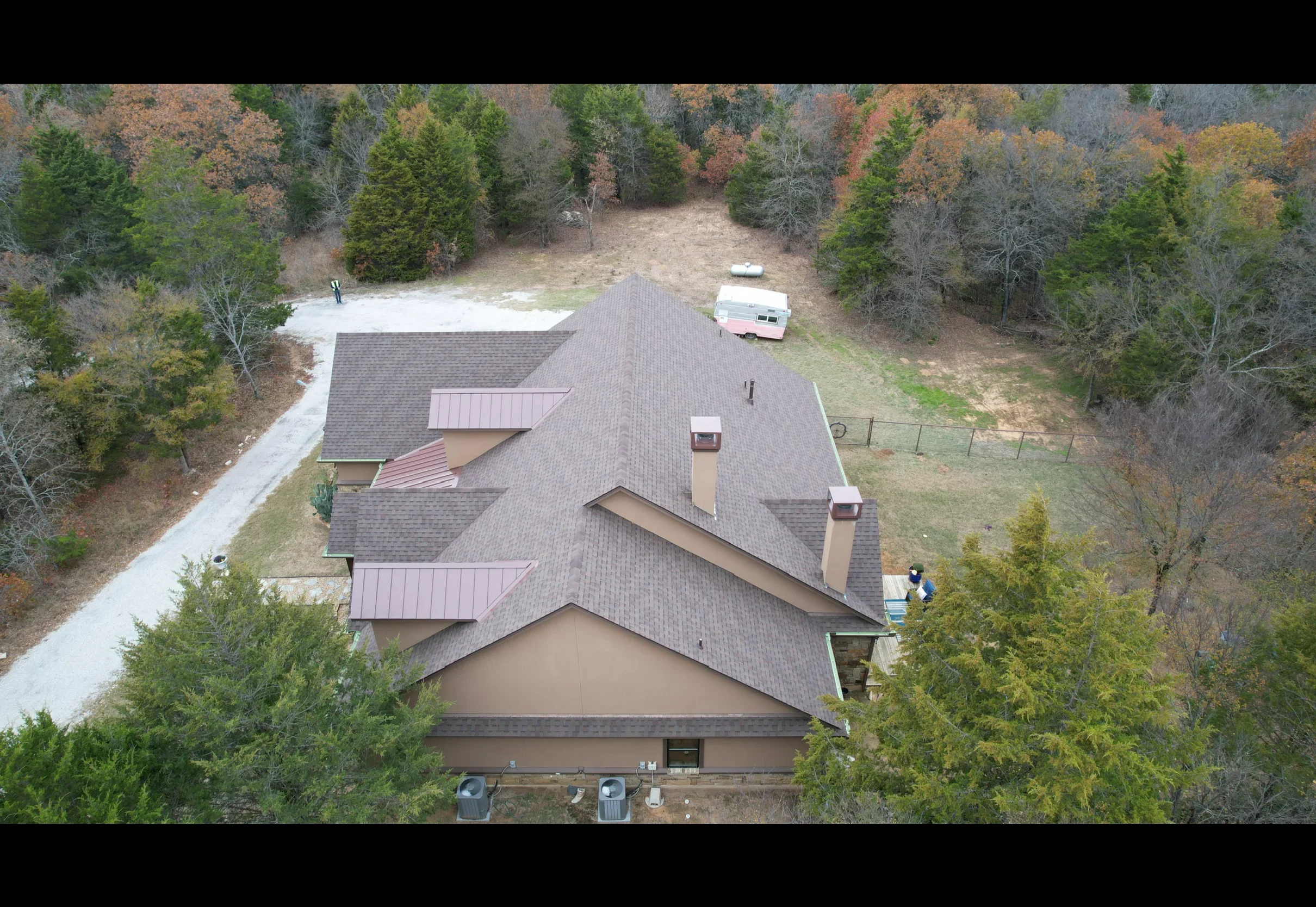 Aerial view of residential home with burgundy and gray standing seam metal roof installation