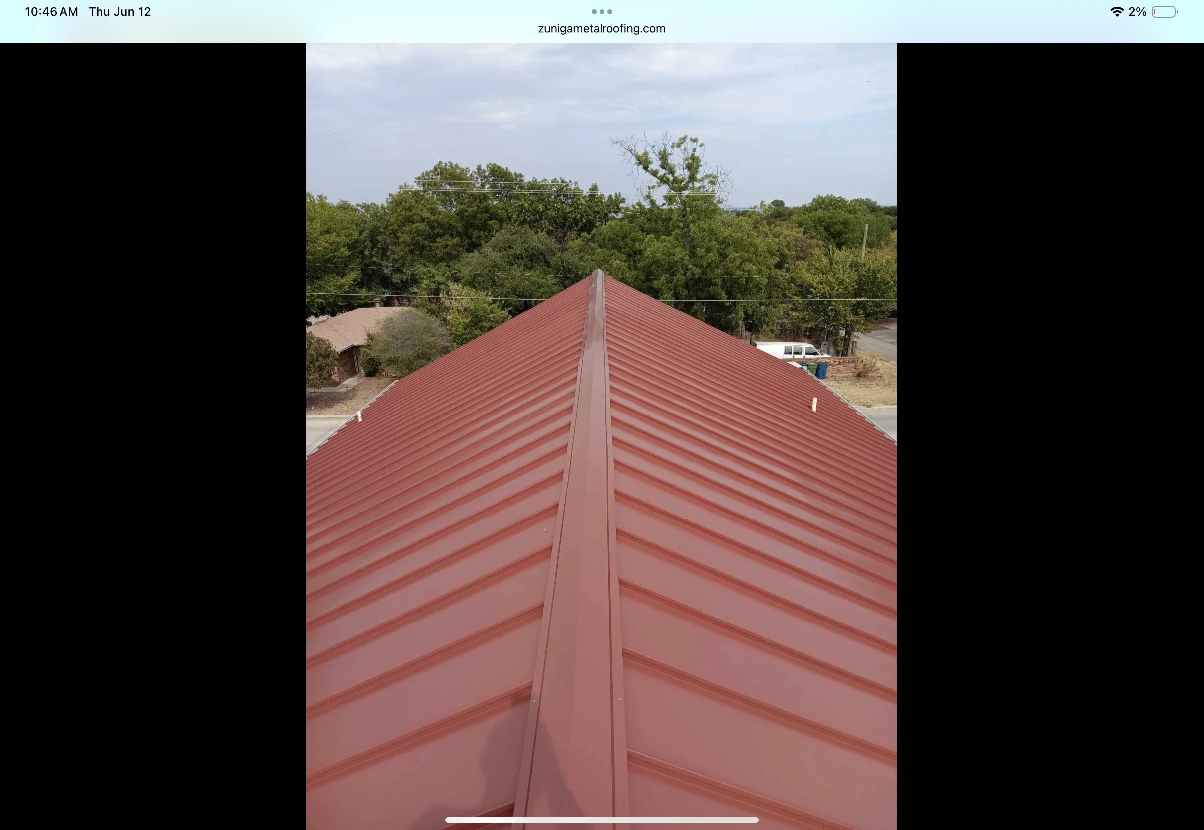 Red corrugated metal roof with standing seam ridge cap and symmetrical panel layout