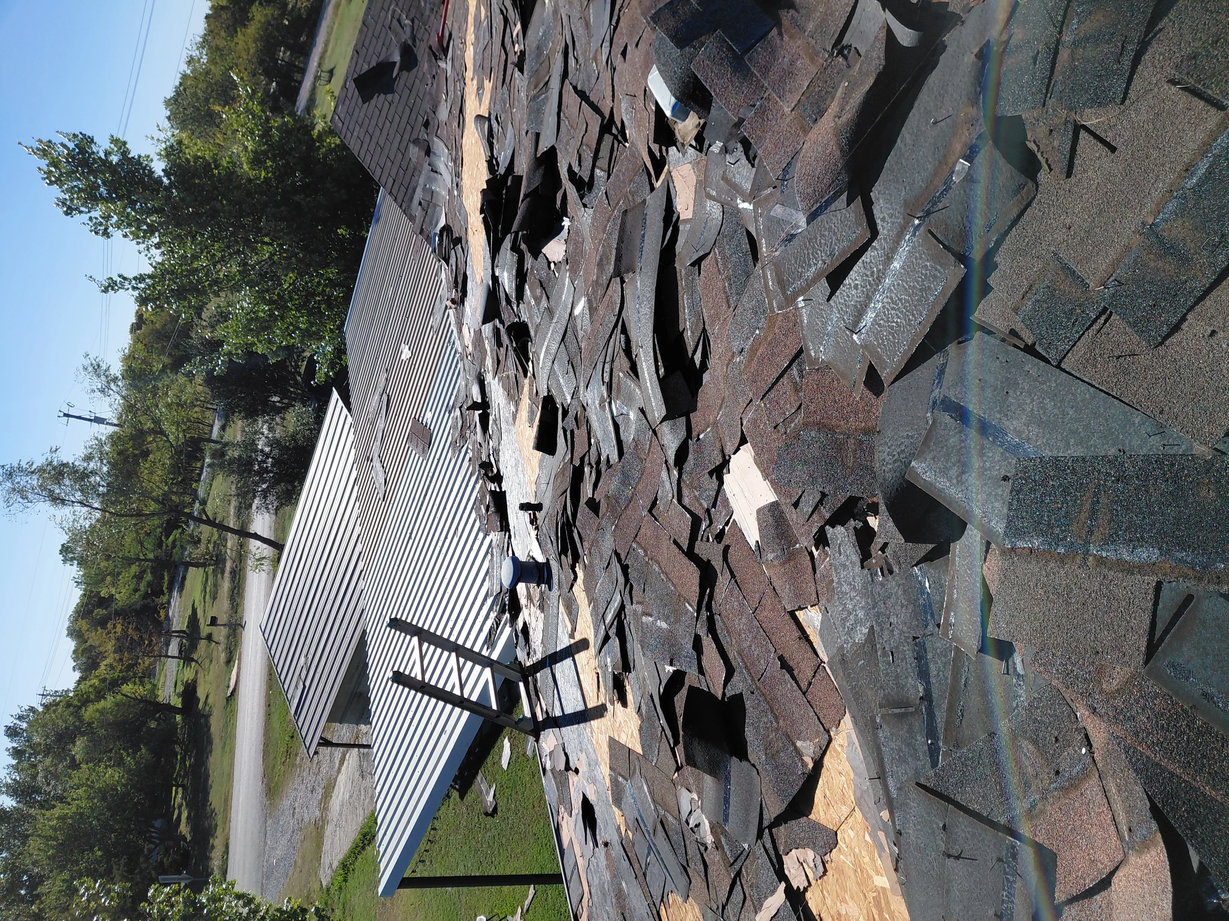 Asphalt shingle roof installation with mixed-tone shingles and metal flashing details